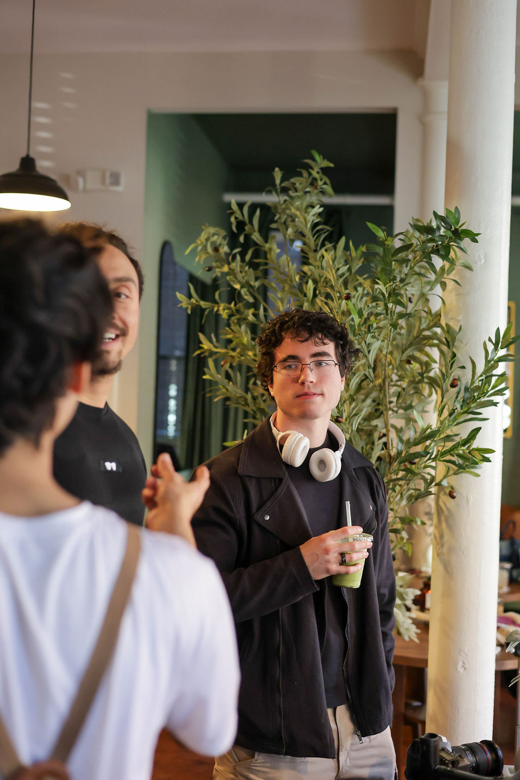 Guests talking and laughing together, one holding a cold matcha drink